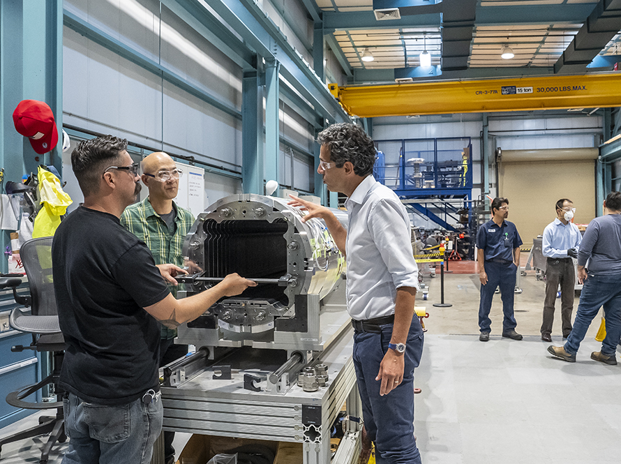 Two scientists adjust equipment at the Associated Particle Imaging (API) Test Stand