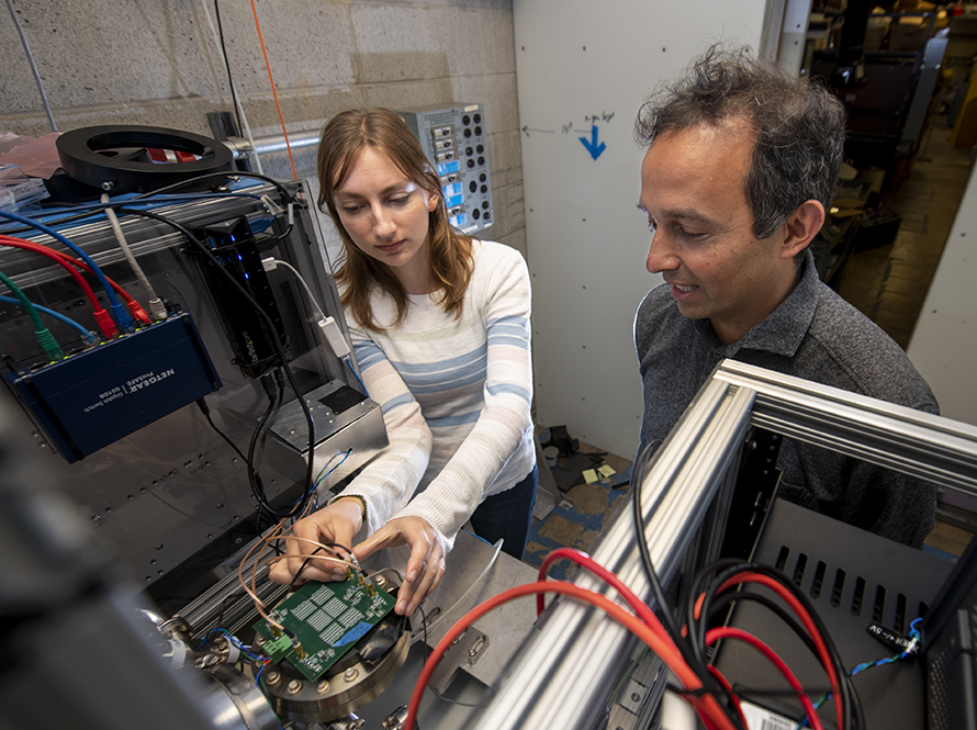 Researchers work on lab equipment