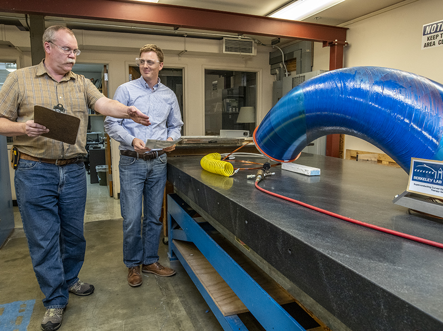 Researchers examine a large-diameter blue curved magnet