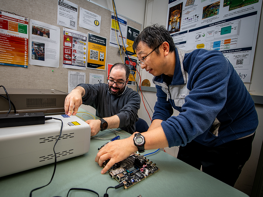 Two researchers working at an electronics bench