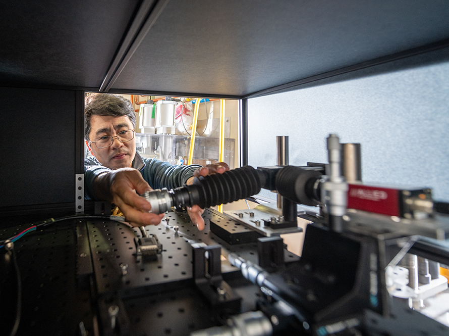 Researcher adjusts diagnostic beamline equipment on an optical table