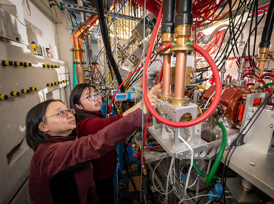 Two researchers examine equipment at electron beamline