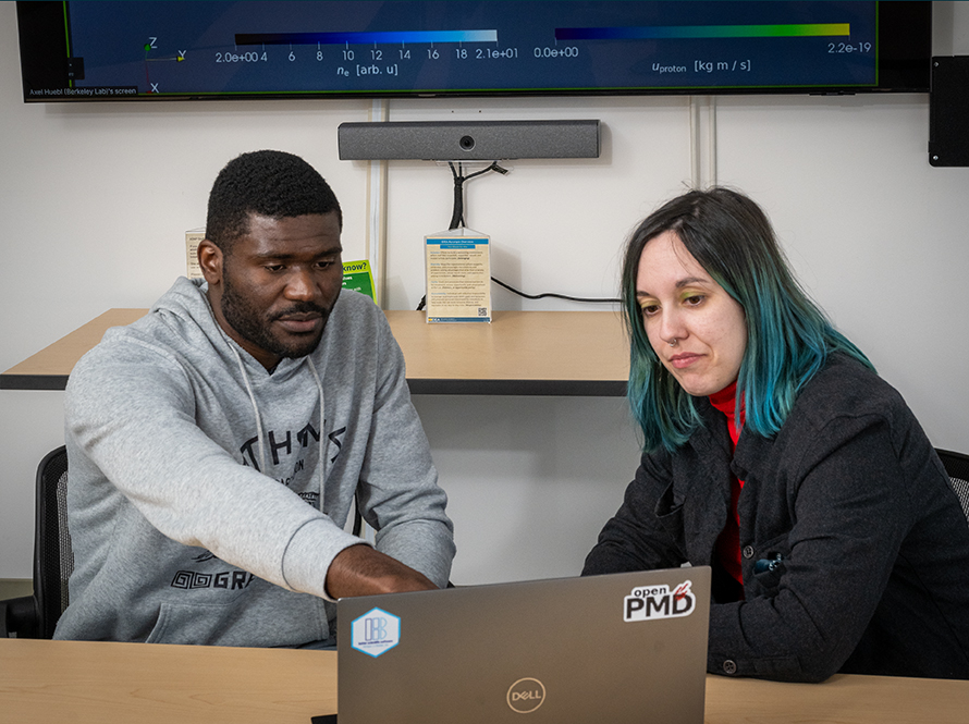 Student and mentor at a computer in an office.