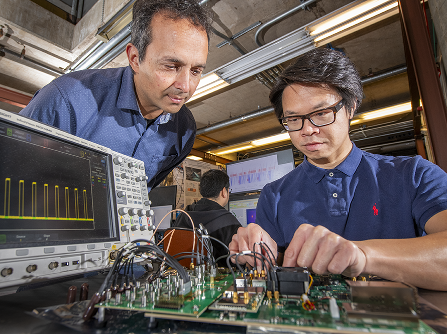 Two researchers work on a circuit board